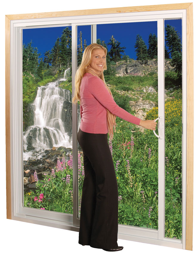 A woman opening clear sliding glass doors