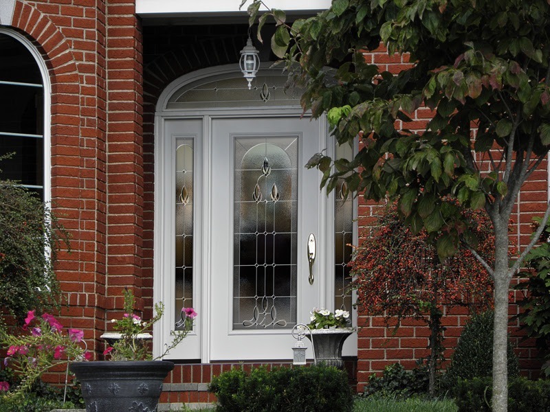 A white front door with frosted main and side glass panels